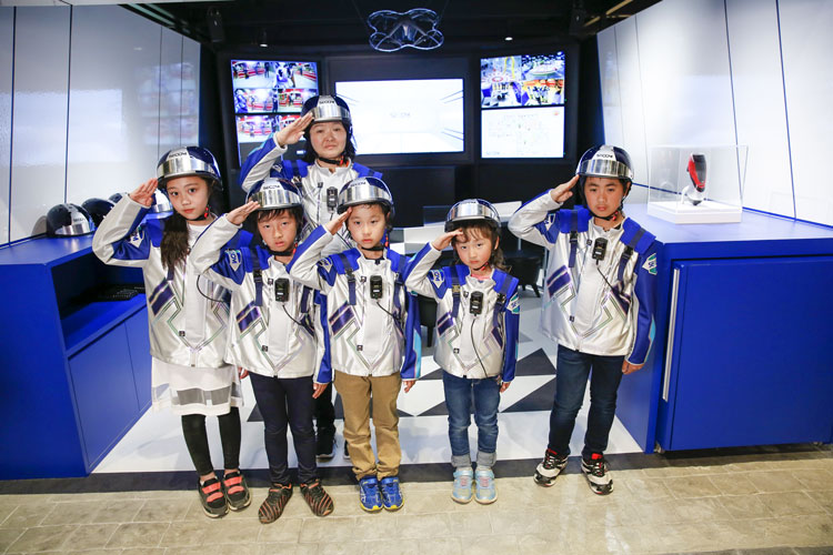 写真:セコムブースの前で近未来的な制服を着る子どもたち